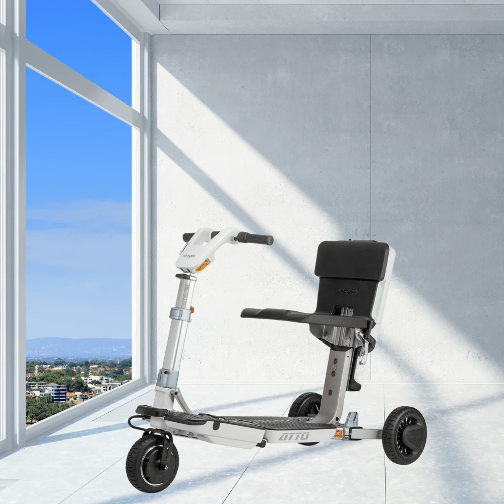 Atto Mobility engelli scooter pencere önünde — şehir manzarası eşliğinde iç mekan kullanım sahnesi